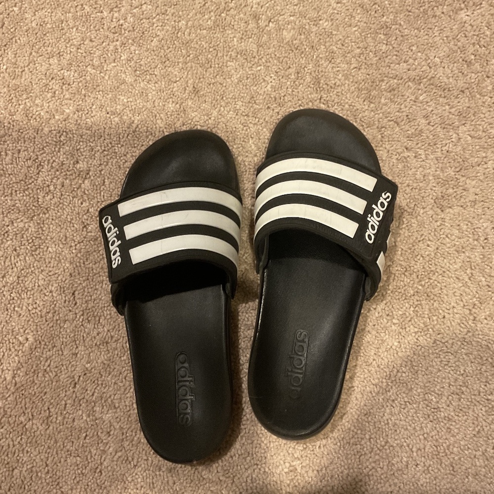Comfortable and stylish, these Adidas kids slides feature a classic black and wh